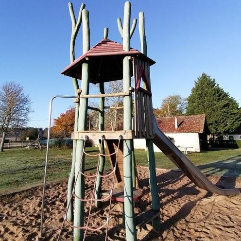 Tour de jeux en bois avec toboggan sur l'aire de jeux du domaine