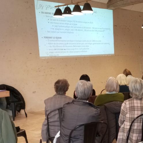 Groupe de séminaire assis face à l'écran, dans la grange