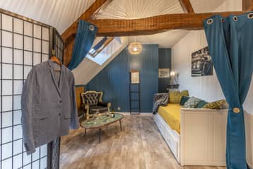 Chambre de l'auberge, lit de repos et veste suspendue