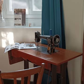 Machine à coudre ancienne et livre posés sur un bureau
