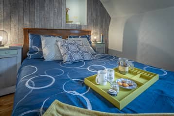Chambre du manoir, lit bleu et plateau de petit déjeuner