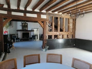 Grande salle aux poutres apparentes du manoir