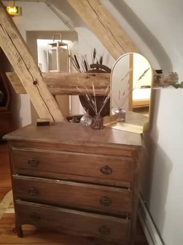 Commode ancienne et miroir sous les poutres
