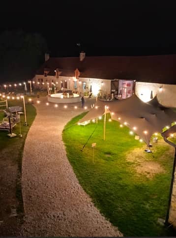 Chemin gravillonné éclairé de guirlandes dans la cour, de nuit