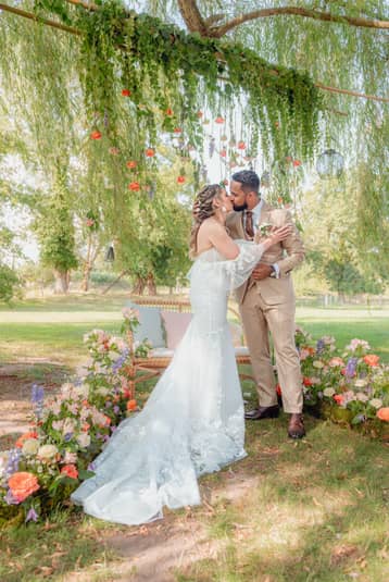 Mariés sous une arche de verdure et de fleurs