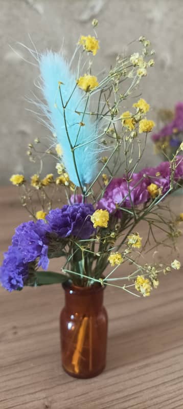 Bouquet de fleurs sauvages dans un petit flacon en verre brun