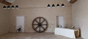 Salle vide de la grange, roue de charrette contre le mur