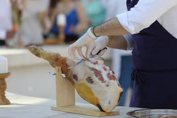 Découpe d'un jambon sur son support, par le cuisinier