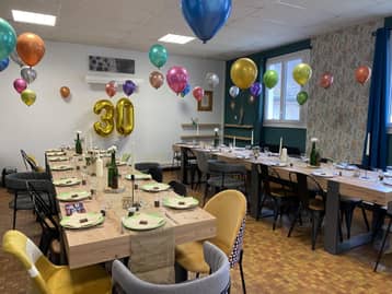 Salle d'anniversaire décorée de ballons, table dressée
