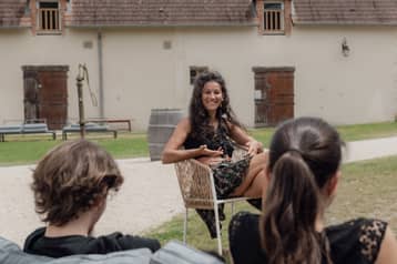 Trois personnes en discussion dans la cour du domaine