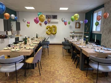 Salle d'anniversaire décorée de ballons, table dressée