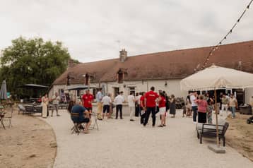 Soirée dans la cour du domaine, invités sous les guirlandes lumineuses