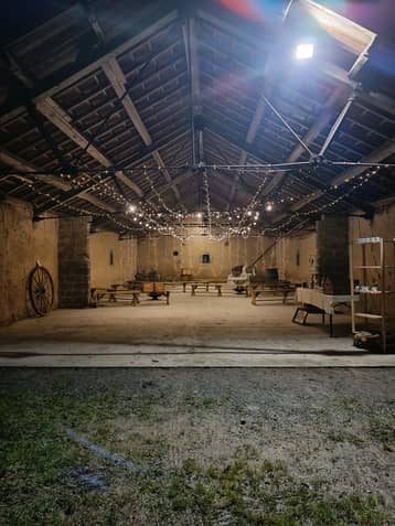 Grange éclairée de guirlandes, ambiance cosy sous la guinguette