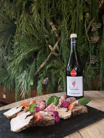 Bouteille de beaujolais nouveau et planche de charcuterie