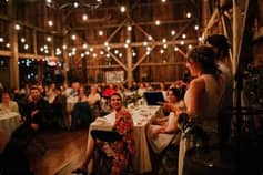 Grange dressée pour un dîner de mariage, guirlandes lumineuses