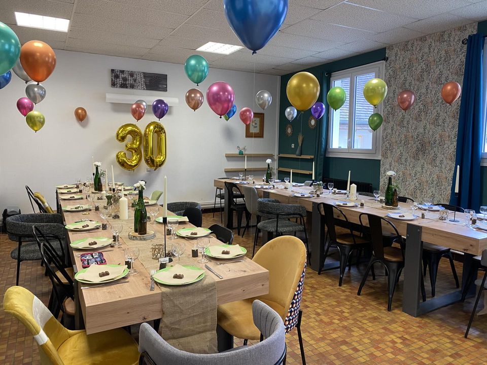 Salle d'anniversaire décorée de ballons, table dressée