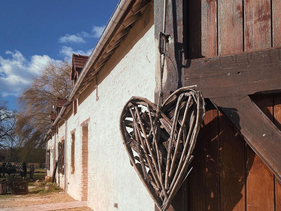 Grange blanche avec un coeur en osier accroché à la porte