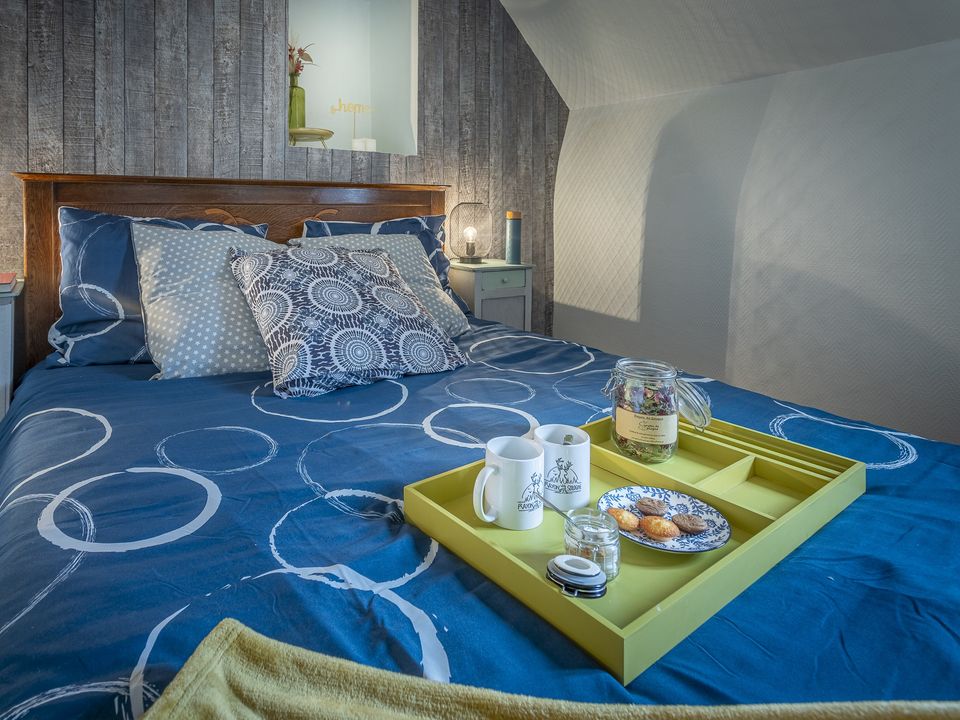 Chambre du manoir, lit bleu et plateau de petit déjeuner