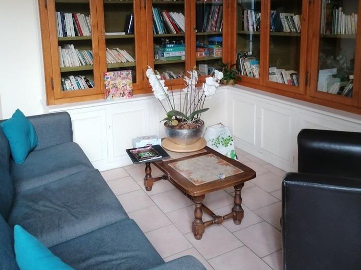 Salon-bibliothèque du gîte, canapé bleu et étagères de livres