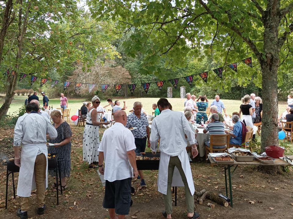 Repas d'anniversaire en extérieur, convives sous les arbres