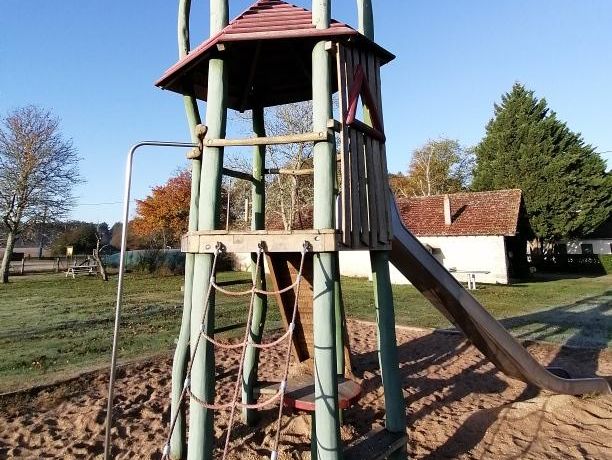 Tour de jeux en bois avec toboggan sur l'aire de jeux du domaine