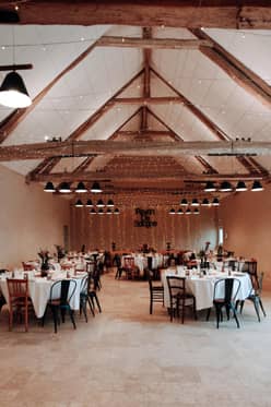 Grange aménagée pour un repas, tables rondes dressées