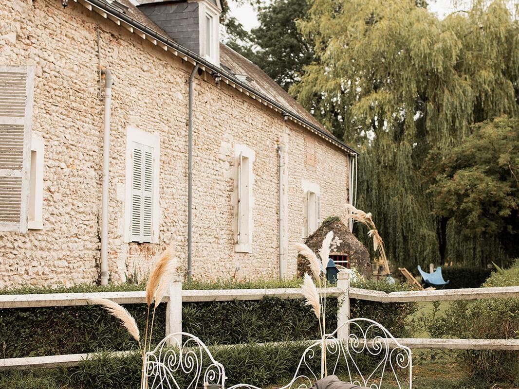Lit de repos en fer devant la maison en pierre du domaine